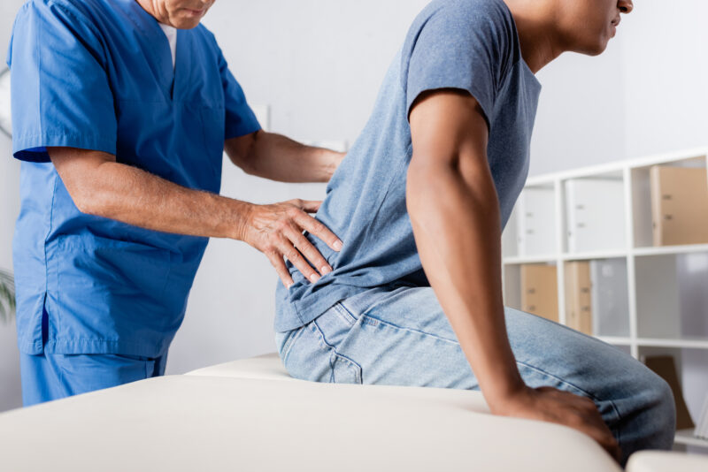 Doctor helping patient with back pain issues 